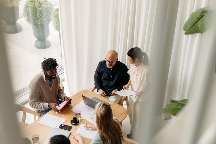 Group working together at desk birdseye view